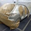 Voiture avec marouflage avant peinture dans un atelier de carrosserie